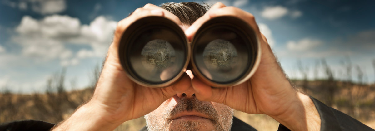 man looking through binoculars